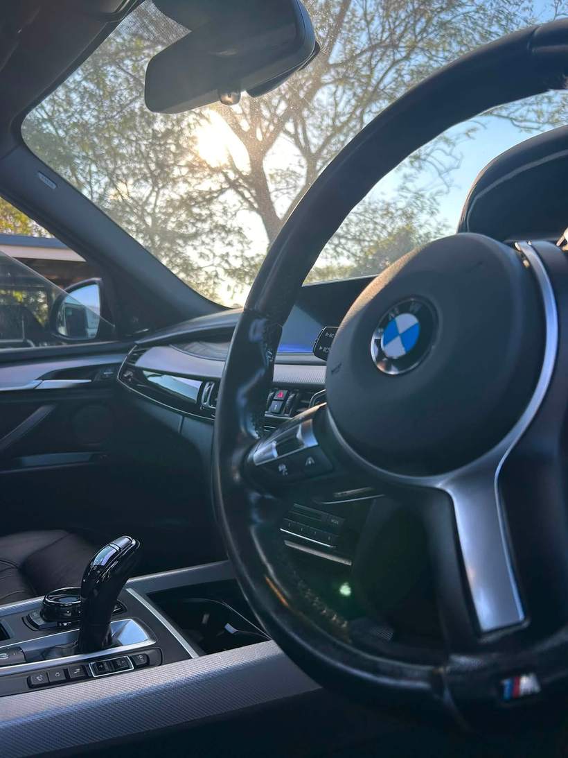 BMW X5 cabin and steering wheel at sunset