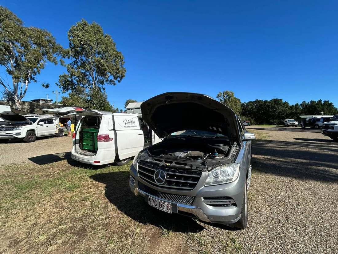 Mercedes SUV with bonnet raised beside the Unreal Auto Care van