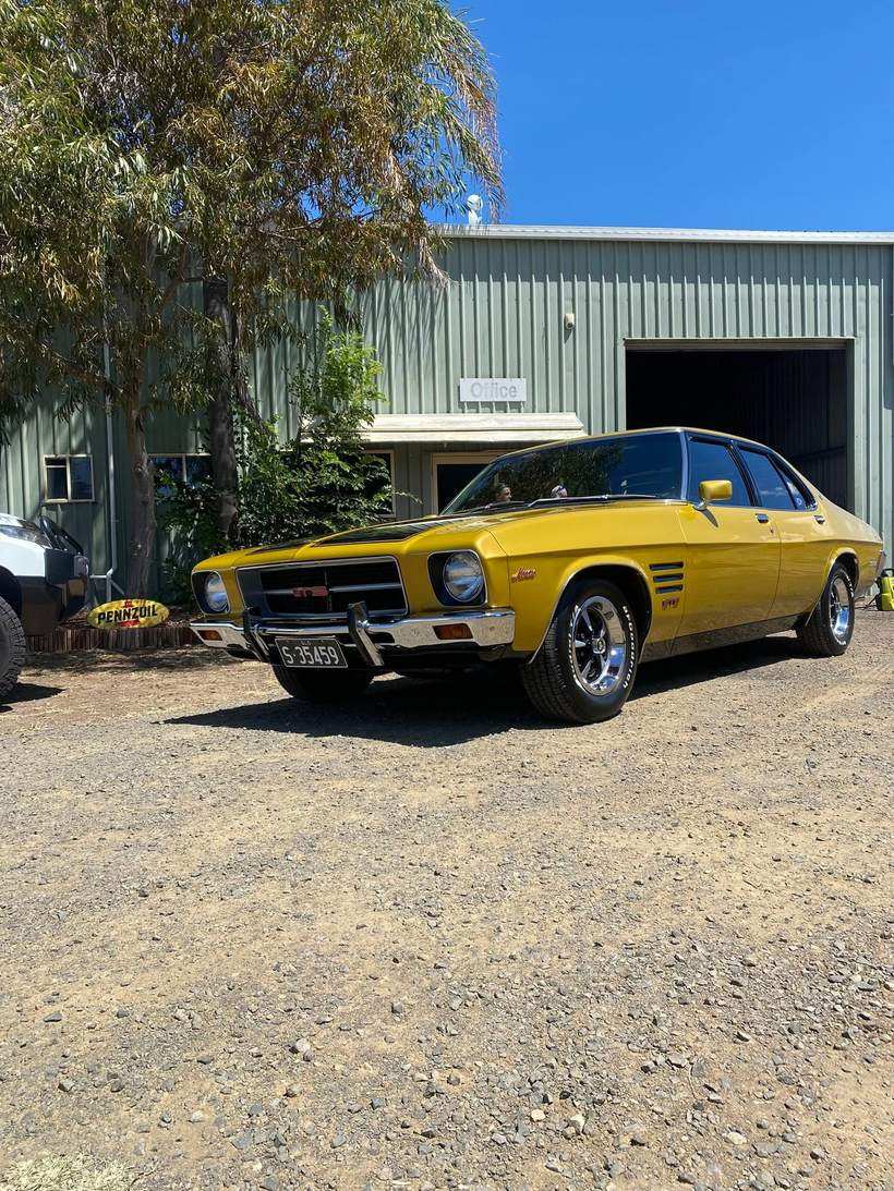 Yellow HQ Monaro GTS parked outside a shed