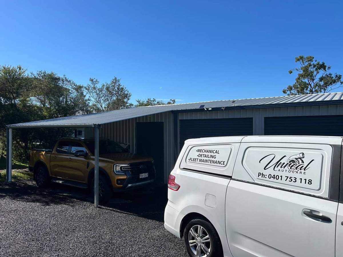 Unreal Auto Care van parked at a service shed